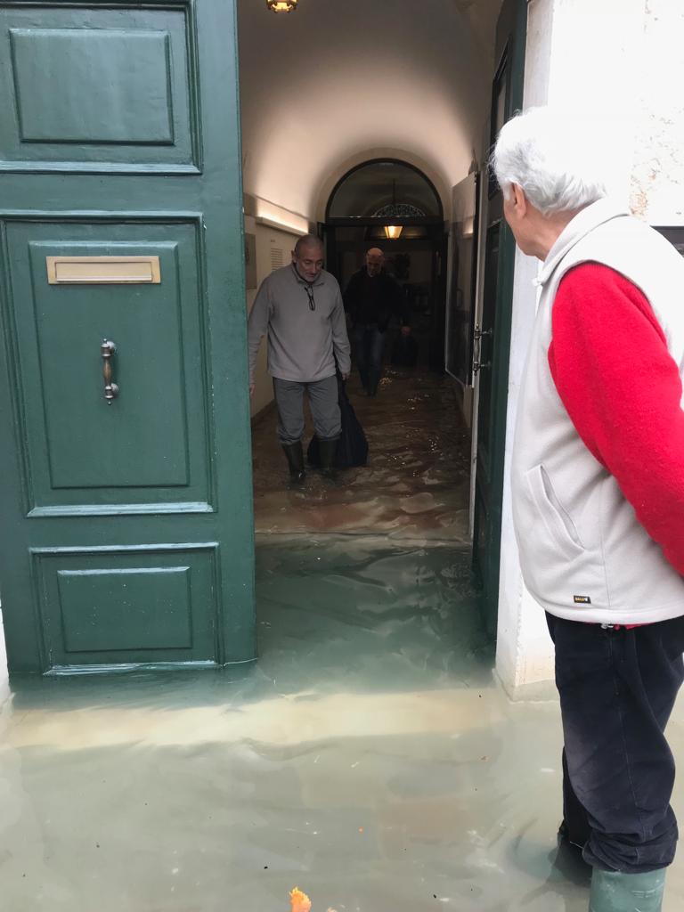 Bepi sorveglia gli operai che portano fuori centinaia di chili di carte e altro bagnati